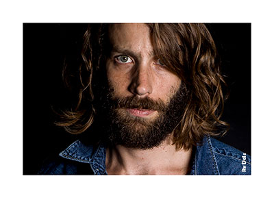 Portrait photo d'un homme avec une barbe et une chemise en djean.